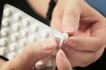 Hands taking out a tablet from a blister pack